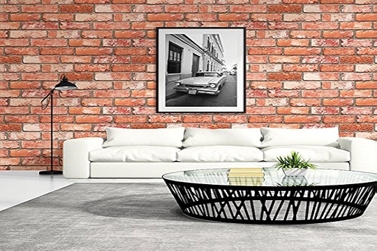 A brick wall in a living room with a sofa and coffee table.